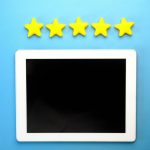 Tablet with five yellow stars on a blue background, ideal for rating concepts.