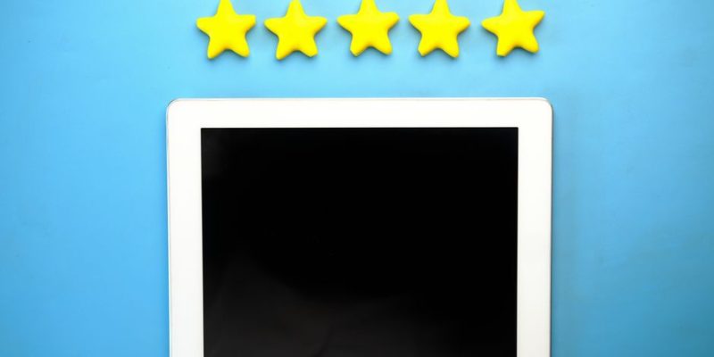 Tablet with five yellow stars on a blue background, ideal for rating concepts.